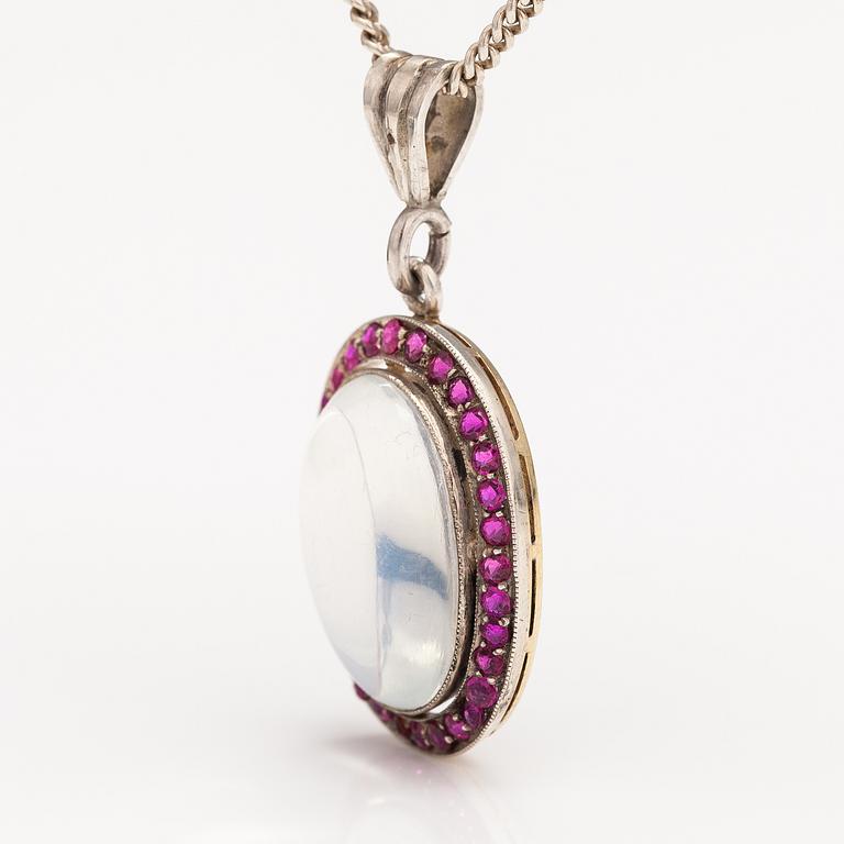 A 14K gold and silver necklace with a moon stone, rubies and a red glass stone.