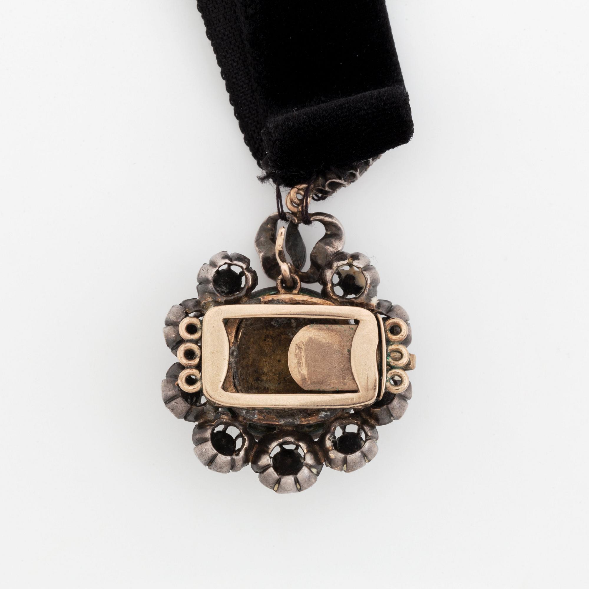 A silver pendant with a pearl and rose-cut diamonds.