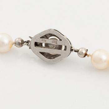 Pearl necklace, cultured pearls, silver clasp with white stones.