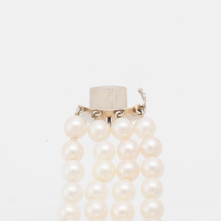 Bracelet 4-row with cultured pearls, round brilliant-cut and baguette-cut diamonds, and clasp in 14K white gold.