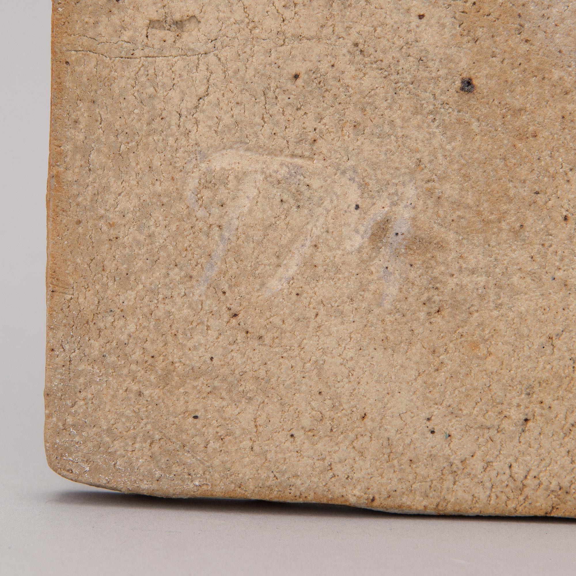 A stoneware art plate signed TM.