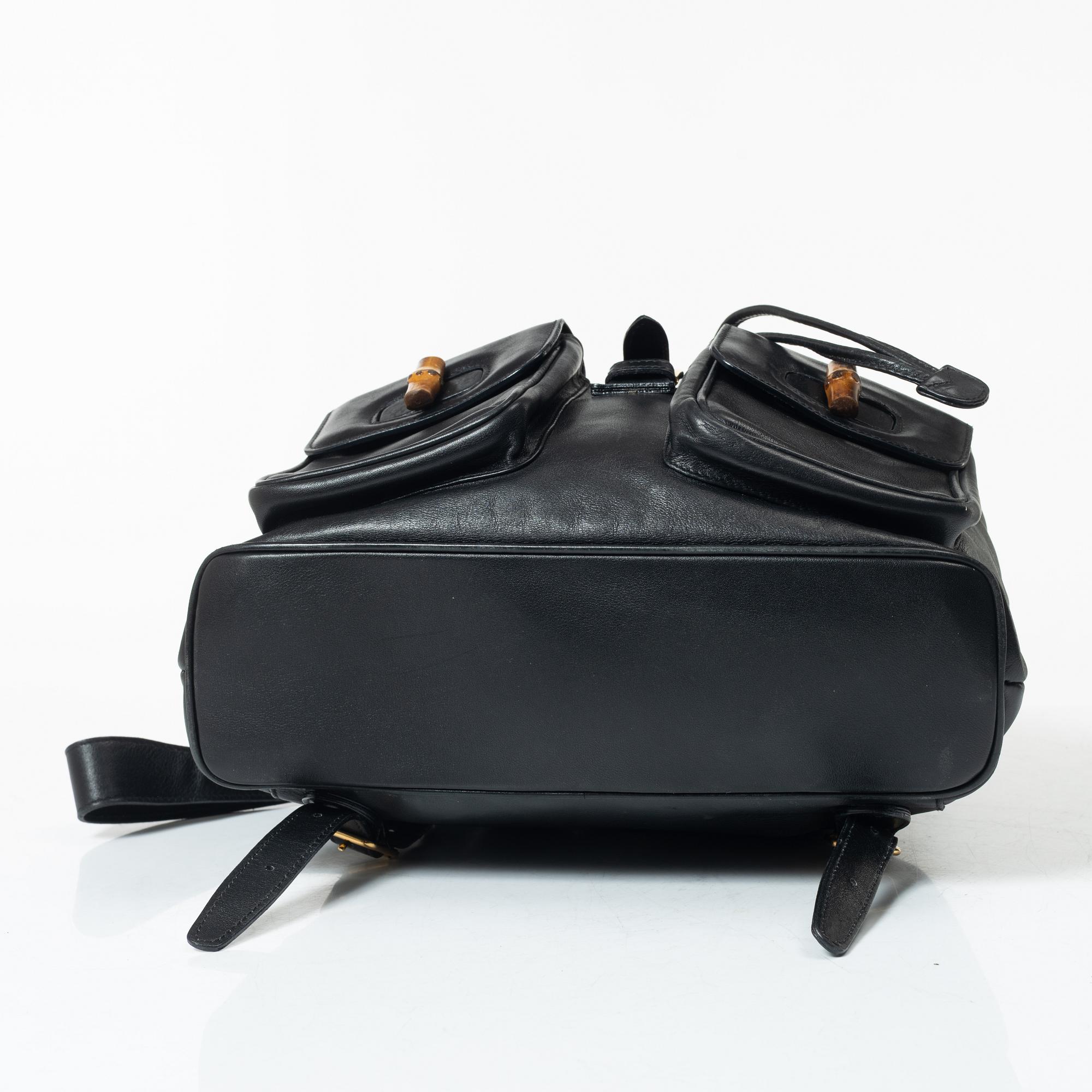 Gucci, A black leather backpack.