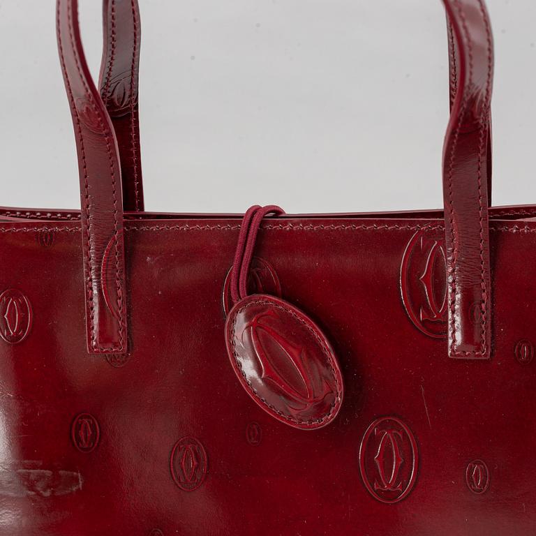 Cartier, a burgundy patent leather handbag and wallet.