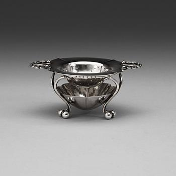 A Georg Jensen tea strainer on stand, Copenhagen 1915-21, 830/1000 silver.