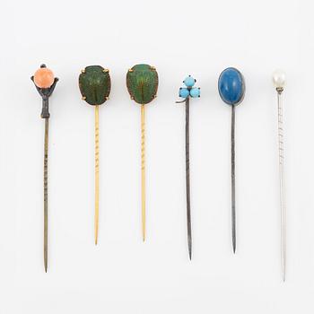 Six brooch pins in various designs and materials.