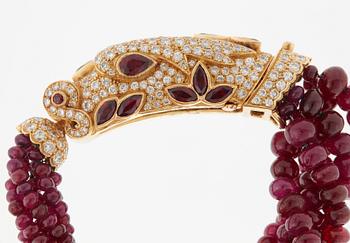 A Cartier chimera head bracelet in 18K gold set with round brilliant-cut diamonds and faceted rubies.