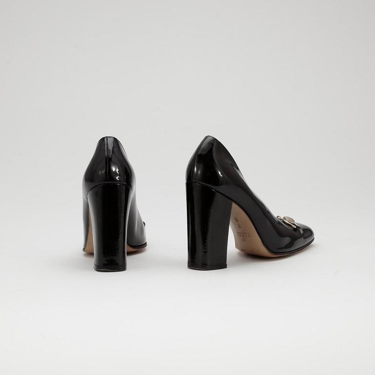 GUCCI, a pair of black patent leather shoes.