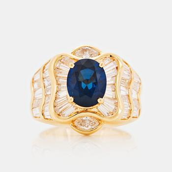 An 18K gold Junod ring set with a facted sapphire and tapered baguette-cut diamonds.