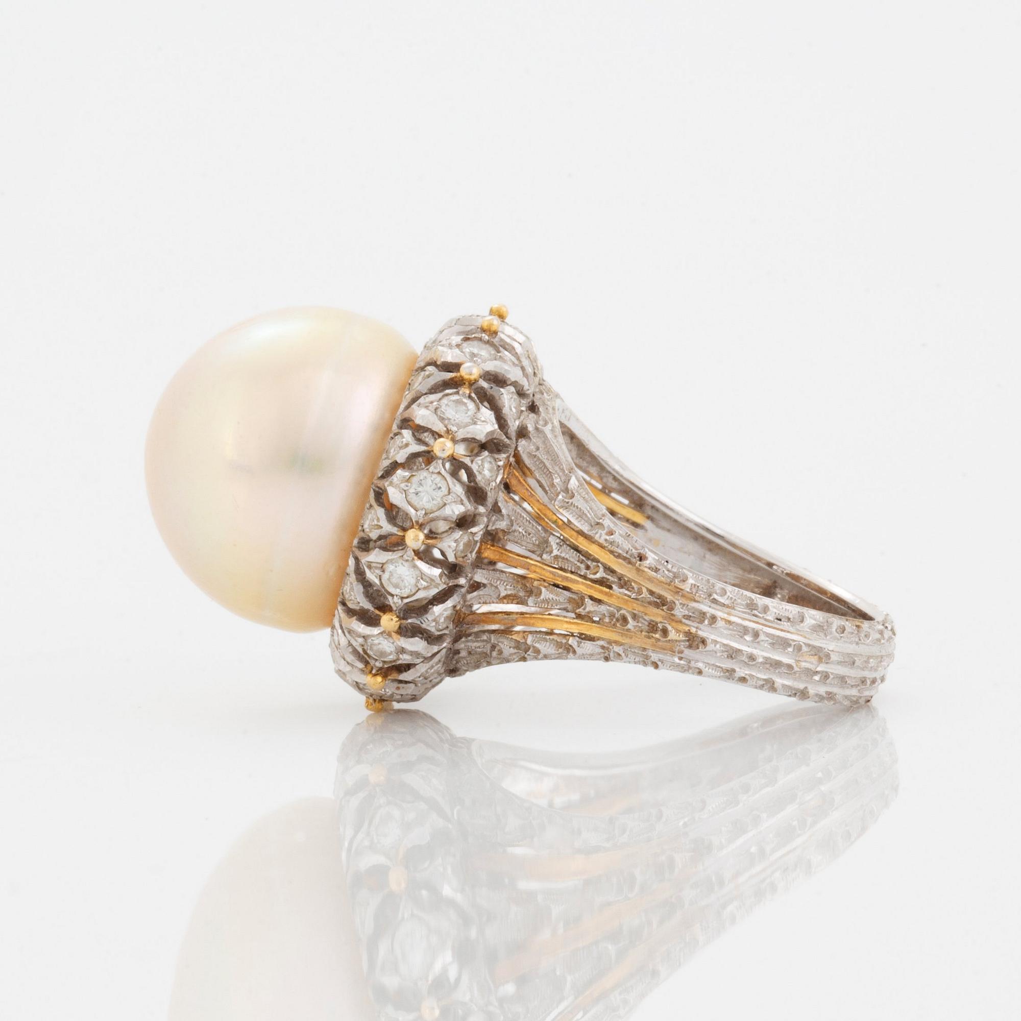 An 18K gold ring set with a cultured pearl and round brilliant-cut diamonds.