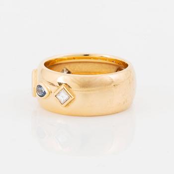 An 18K gold Cartier ring set with step-cut diamonds and faceted sapphires.