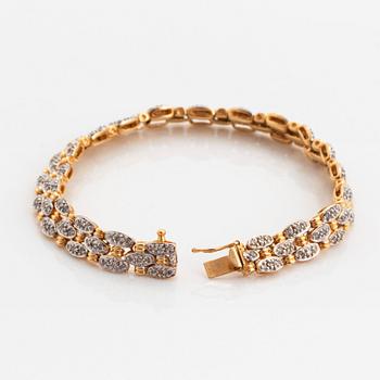 An 18K gold and white gold bracelet set with round brilliant-cut diamonds.