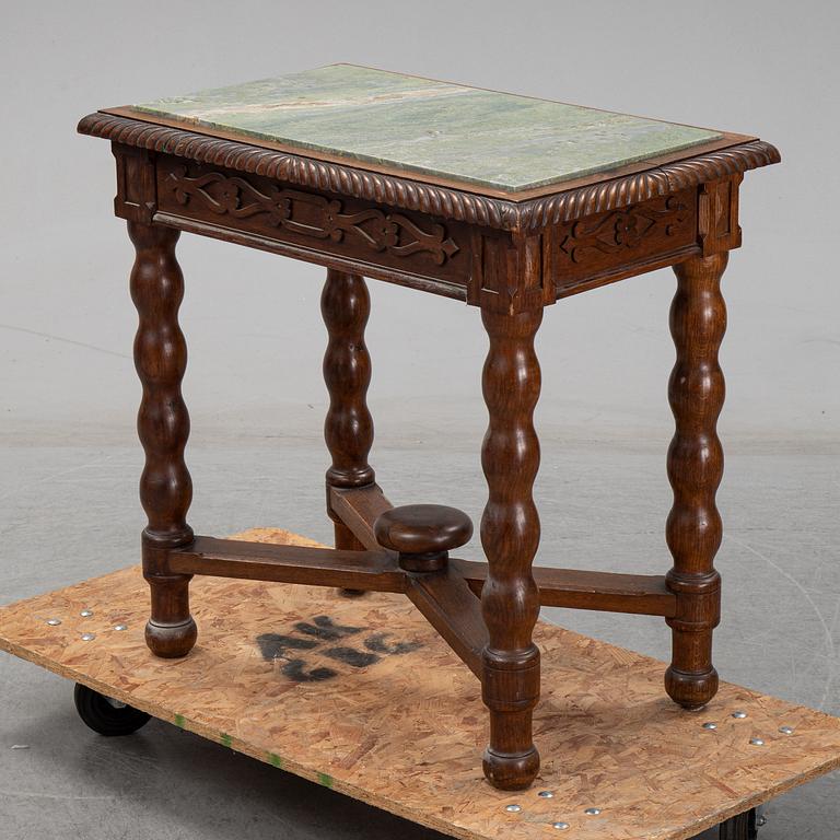 An early 20th Century oak side table with a stone top.