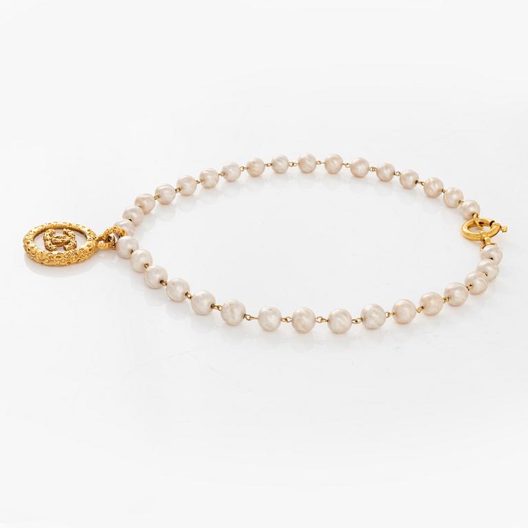 Chanel, A imitation pearl necklace with gold plated CC-charm, 1993.