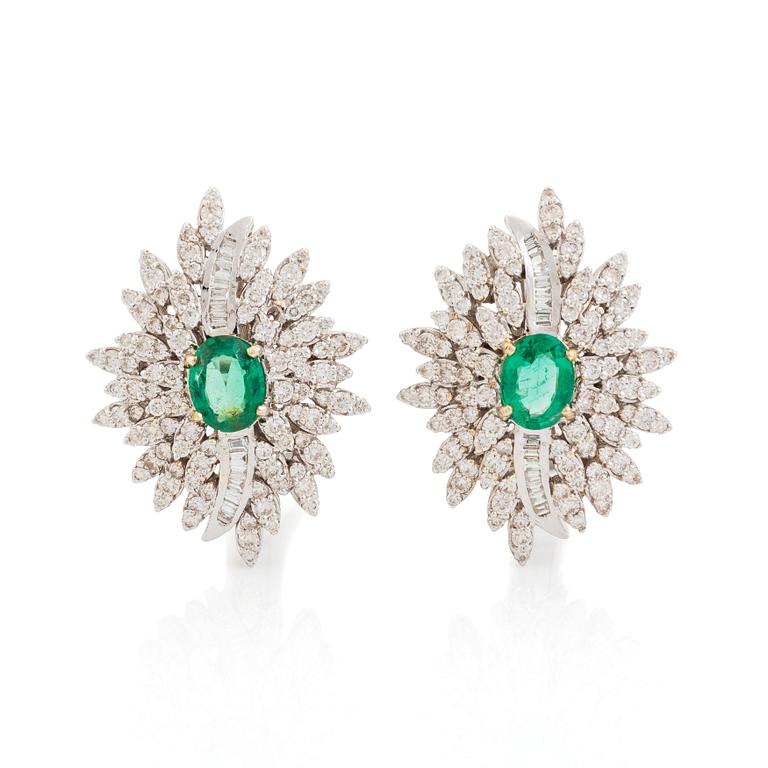 A pair of 18K white gold earrings set with faceted emeralds.