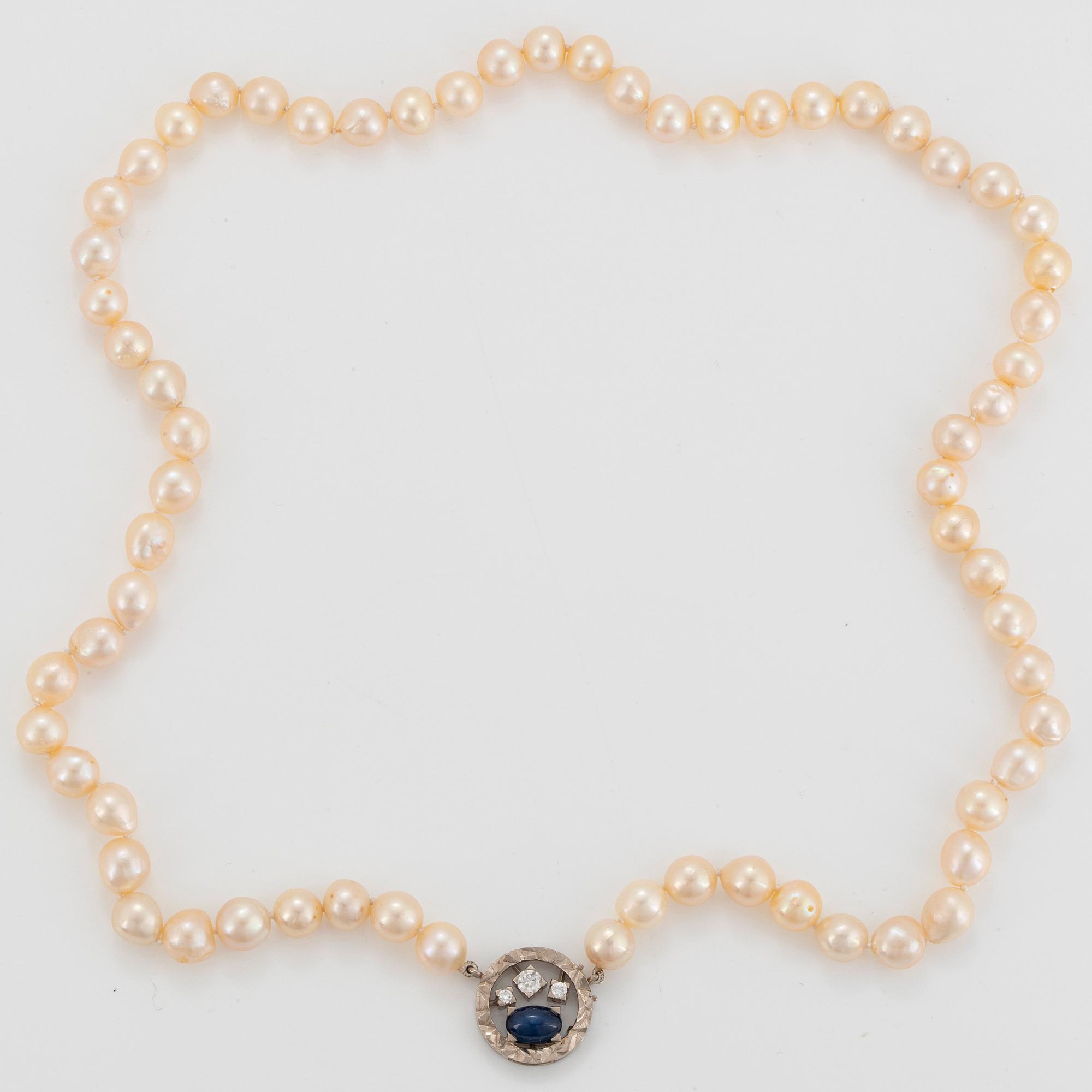 A Rey Urban cultured pearl necklace with an 18K white gold clasp set with a cabochon-cut sapphire.