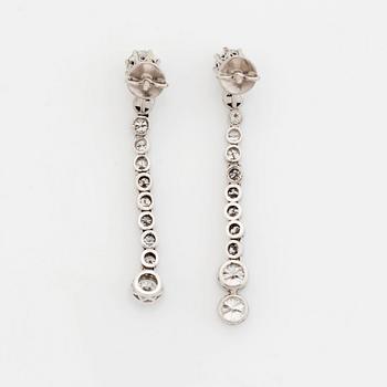 A pair of 18K white gold earrings set with round brilliant-cut diamonds.