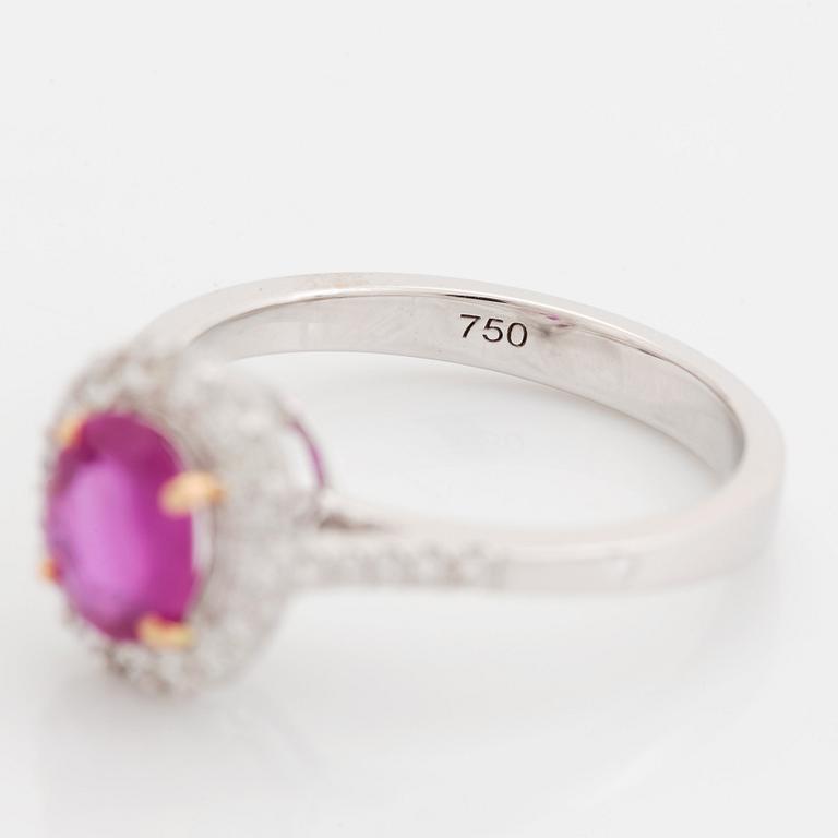 An 18K white gold ring set with a faceted pink sapphire and round brilliant-cut diamonds.