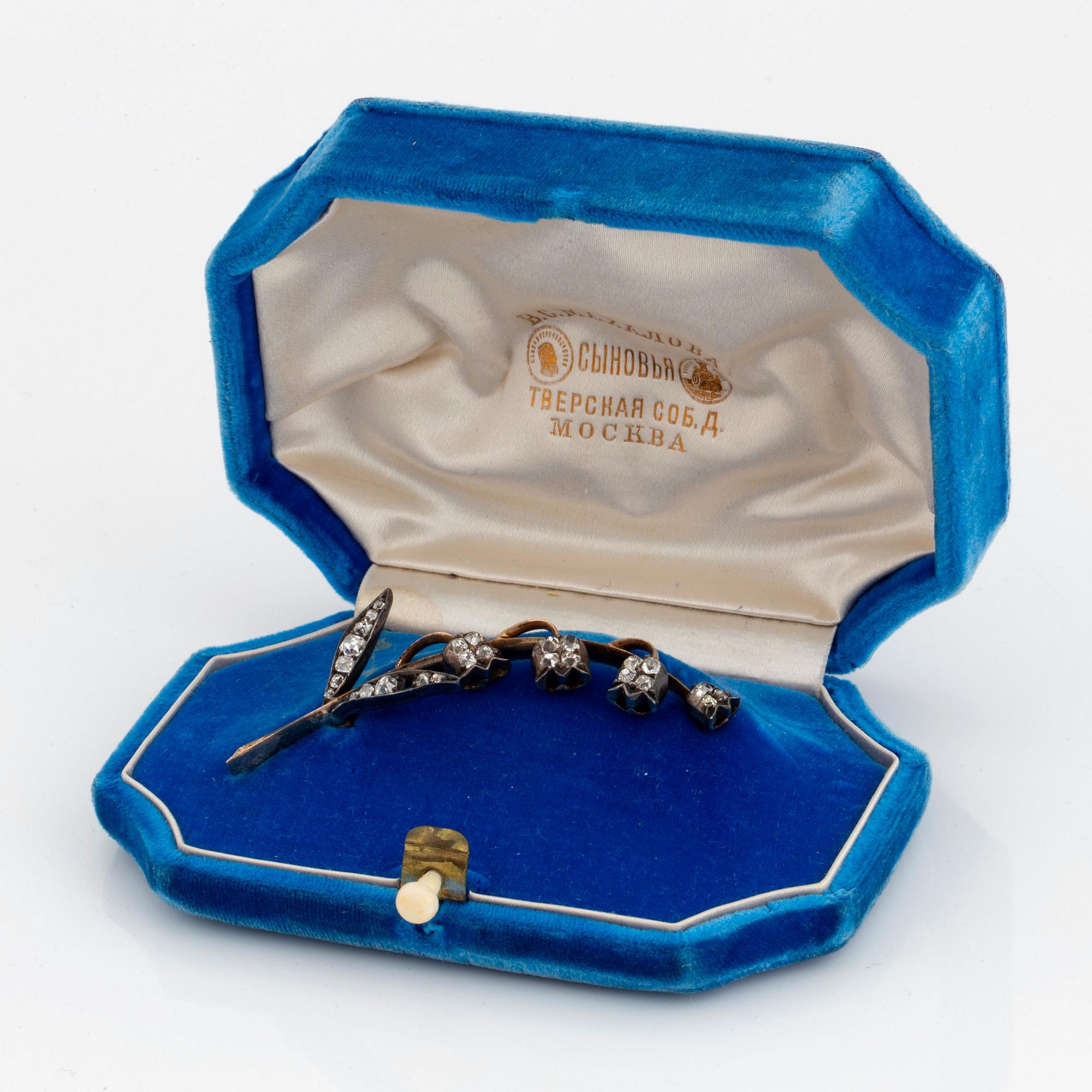 A brooch in 14K gold and silver set with old-cut diamonds, in the shape of a lily-of-the valley twig.