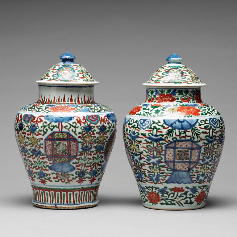 A matched pair of Transitional wucai baluster vases with covers, 17th Century.