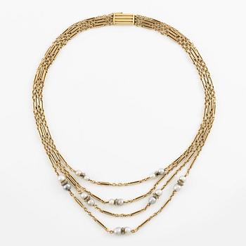 A W.A. Bolin necklace in 18K gold with pearls and white discs.