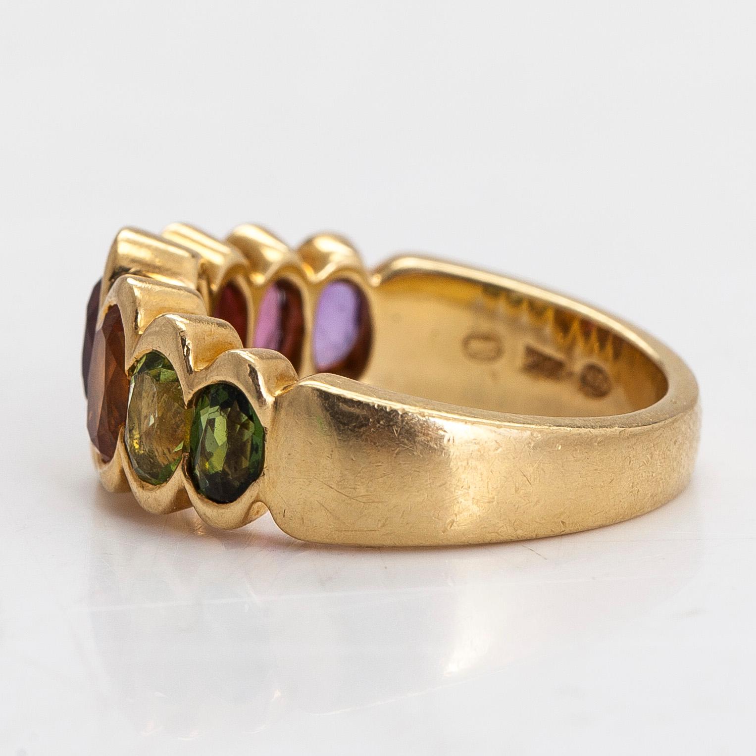 An 18K gold ring, with multi-coloured stones.
