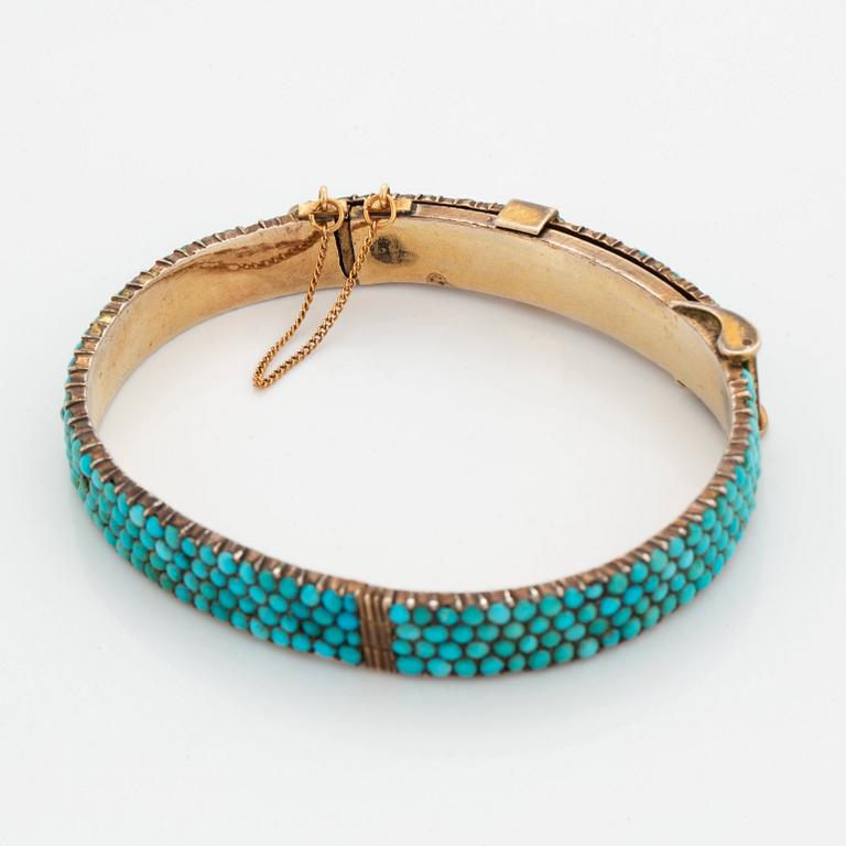 A silver and turquoise bracelet.