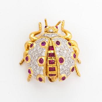 An 18K gold ladybug brooch, with rubies and diamonds.