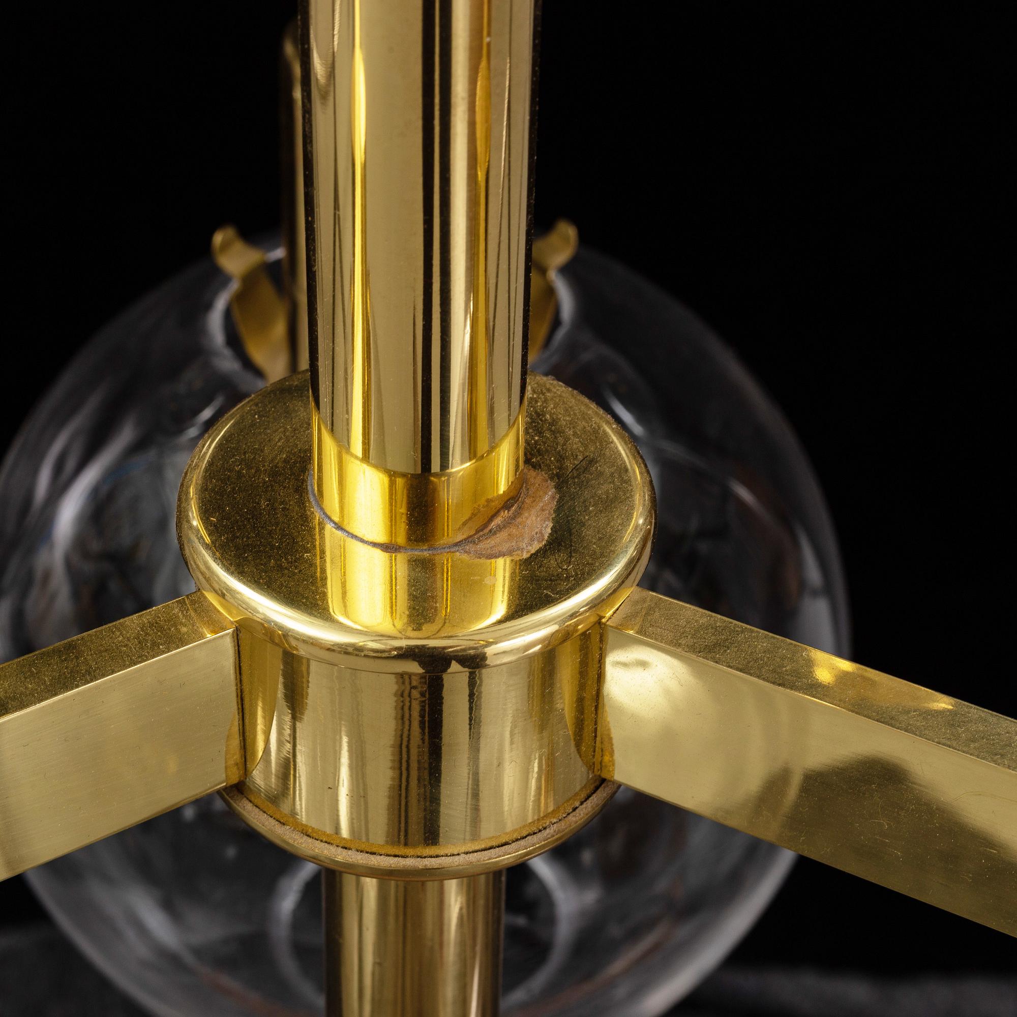 A brass chandelier with glass globes by Hans Agne Jakobsson, Markaryd.