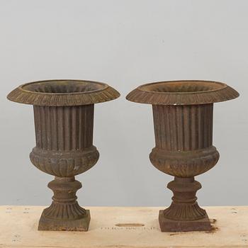 A PAIR OF IRON CAST GARDEN URNS.