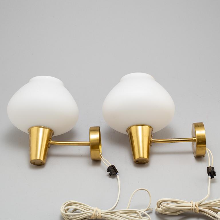 a pair of glass and brass ASEA wall lights from the mid 20th century.