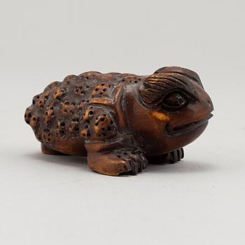 A carved wooden netsuke in the shape of a frog, 20th century.