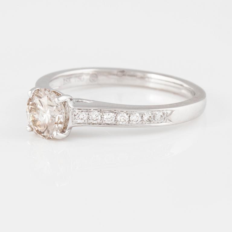 RING, 18K vitguld med briljantslipad diamant ca 0.70 ct samt små briljantslipade diamanter ca 0.10 ct. Vikt 2,9 gram.