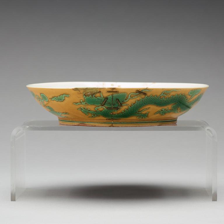 A yellow glazed dish with green five clawed dragons, Qing dynasty, Jiaqings seal mark in underglaze blue (1644-1912).