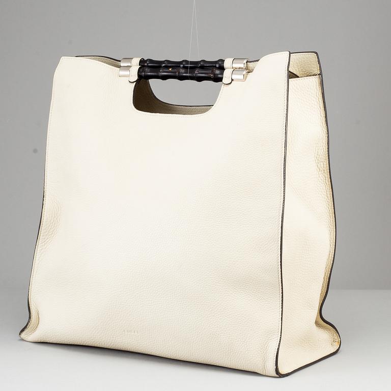 GUCCI, a white leather tote bag with bamboo handles.