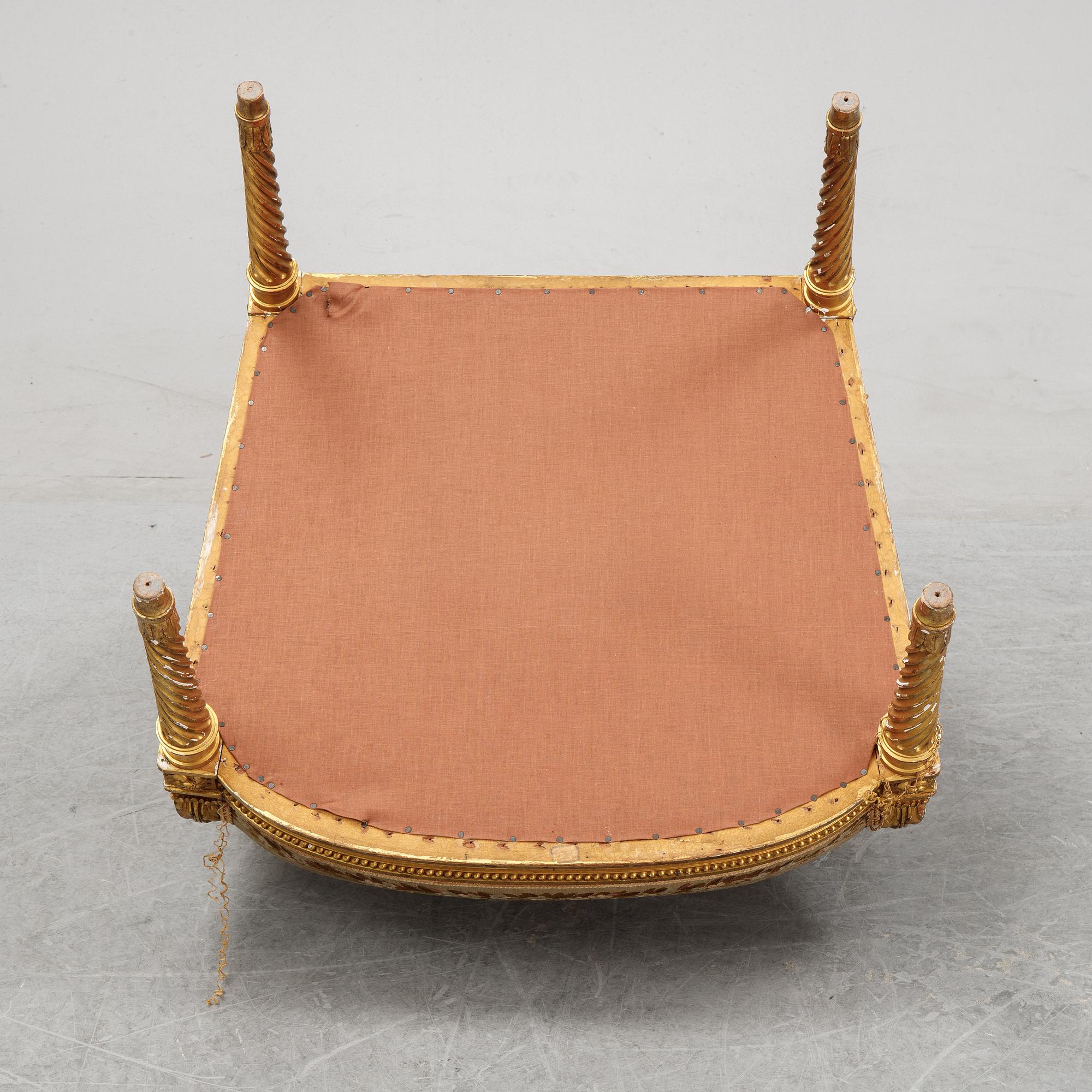 A gilt Louis XVI style armchair from around the year 1900.