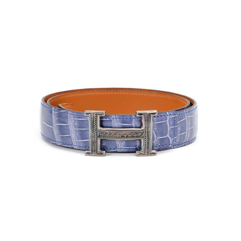 HERMÈS, a lilac crocodile belt with silver colored H-buckle.