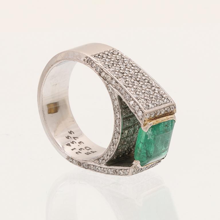 A 9K white gold ring with an emerald and brilliant cut diamonds.