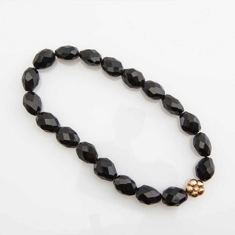 Ole Lynggaard, clasp, 18K gold with a round brilliant-cut diamond, and two necklaces.