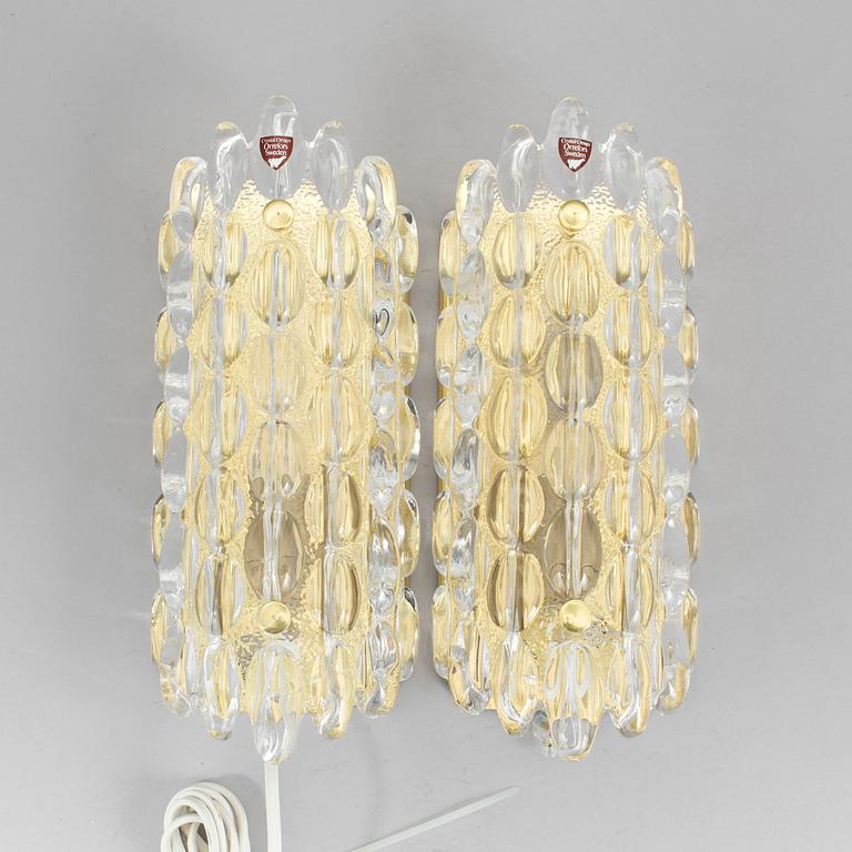 A pair of brass and glass wall lights designed by Carl Fagerlund for Orrefors.