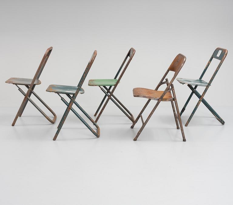 A set of five folding chairs.