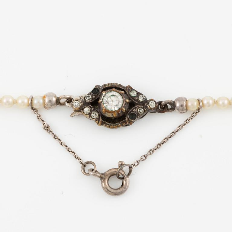 Pearl necklace with graduated cultured pearls, clasp in silver set with pastes, and a pair of pearl earrings,.