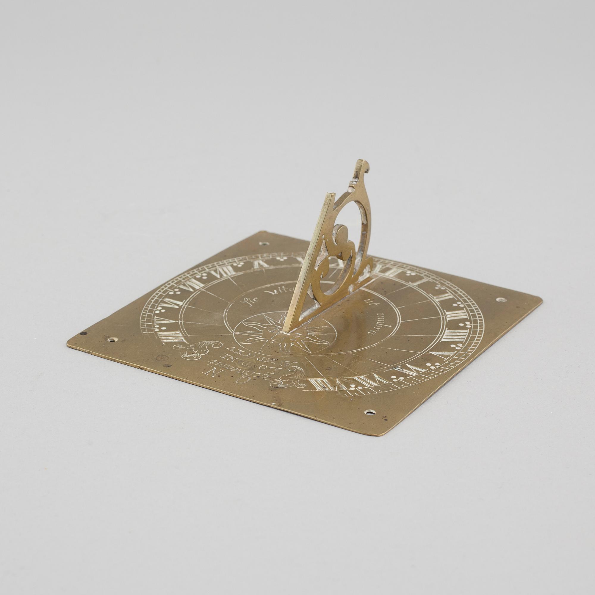 A brass sundial dated 1715.