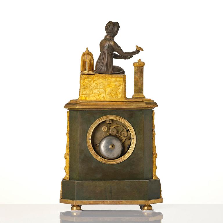A French patinated and ormolu Directoire figural mantel clock, circa 1800.