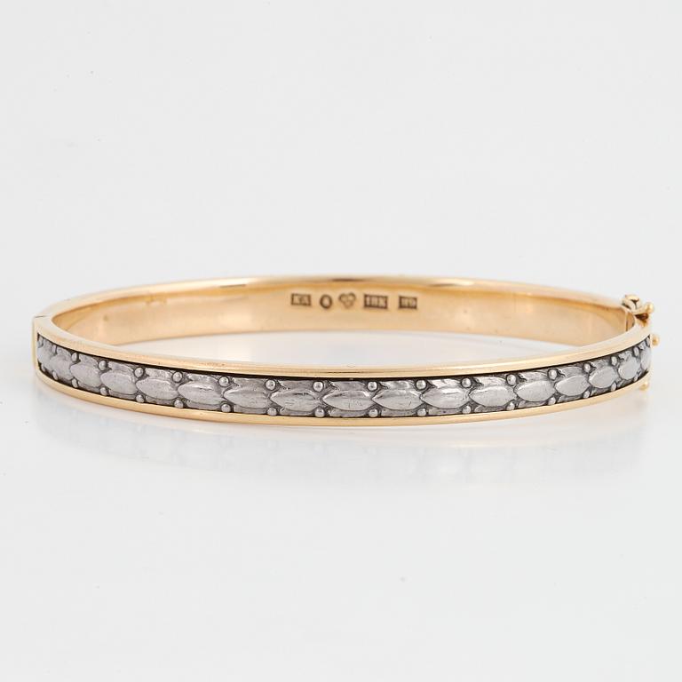 An 18K gold bangle.