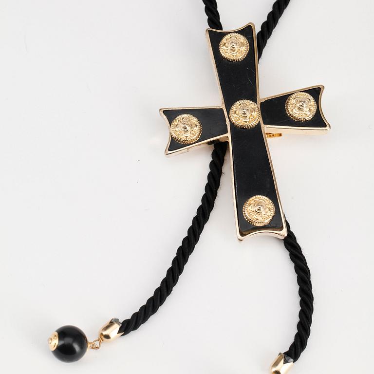 MOSCHINO, a cross necklace.