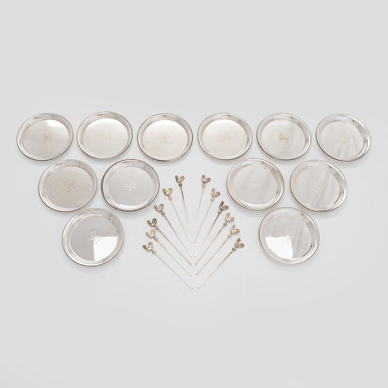 A set of 12 silver glass coasters, Auran Kultaseppä Oy Turku 1935 and 1983, and cocktail sticks, 12 pcs silver.