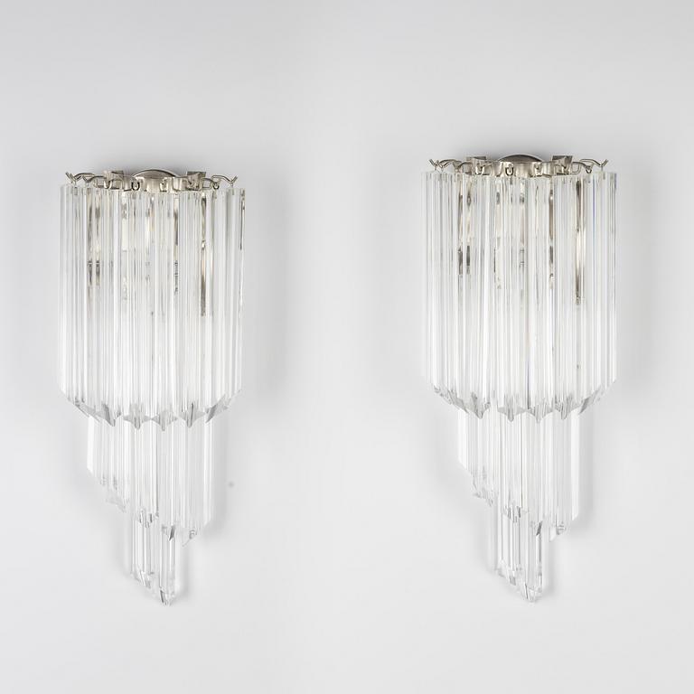 A pair of glass and metal wall lights.