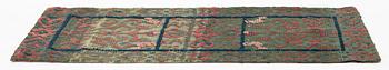 A carrige cushion, knotted pile in relief, c. 106 x 46 cm, Wemmenhögs district, signed AHS KID & KAS dated 1784.