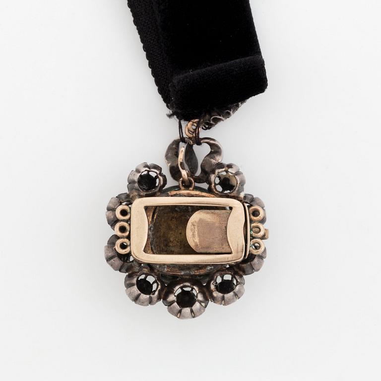 A silver pendant with a pearl and rose-cut diamonds.