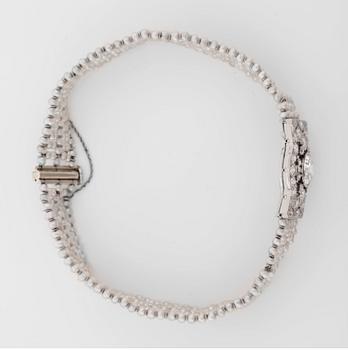 ARMBAND med gammalslipad diamant ca 0.90 ct, orientaliska pärlor samt mindre diamanter, totalt ca 1.00 ct. Ca. 1920-tal.